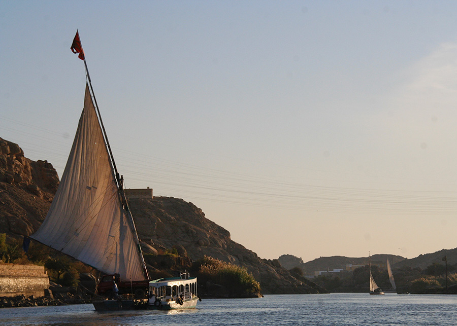 Felucca being torn by motorboat against the current across the Cataract Felucca being torn by motorboat against the current across the Cataract